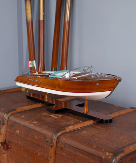 Elegant Riva boat model with glossy wooden hull and blue leather seating, in situation