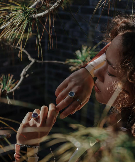 Ring watch elegant by Maison Davis in silver and blue worn on the hand of a woman in a garden