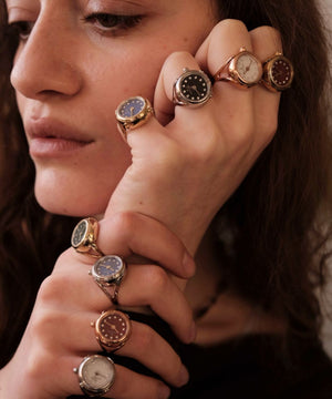 Collection of Maison Davis ring watches worn on a woman’s hand – elegant miniature watch rings